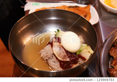 Korean noodle food. Bibim naengmyeon (cold buckwheat noodles) with Korean bbq meat 129909783