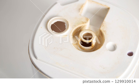 Unpleasant smell, rust and scale from water in the humidifier, white background, close-up Unpleasant smell, rust and scale from water in the humidifier, white background, close-up 129910014