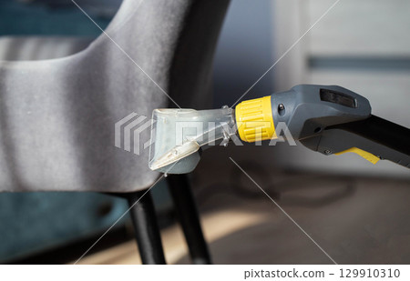 Dry cleaning services, washing and cleaning gray fabric chairs with a washing vacuum cleaner, industry. 129910310