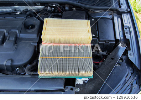 New clean and old dirty air filter in the engine compartment of the car. Technical maintenance of the car, close-up New clean and old dirty air filter in the engine compartment of the car. Technical maintenance of the car, close-up 129910536