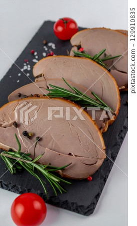 Delicious Sliced Meat Pate with Rosemary and Pepper on Black Slate 129910835