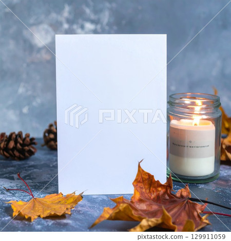 Blank White Card Mockup with Candle and Autumn Leaves on Rustic Background 129911059