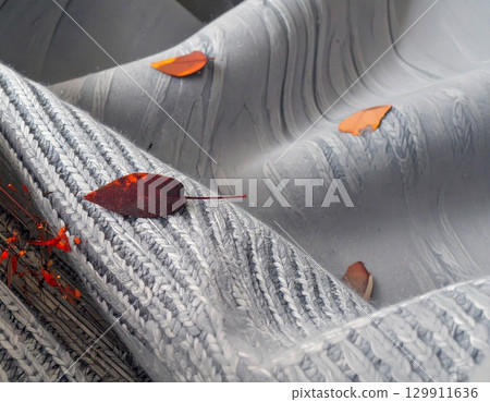 Autumn Leaves on Grey Patterned Fabric with Soft Light Rippled Texture Background 129911636