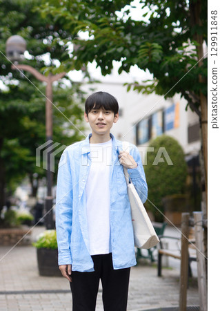 Portrait of a young man walking in the city 129911848