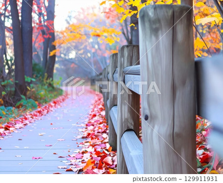 Autumn Trail with Wooden Fence and Colorful Leaves on the Ground in Vibrant Scenery 129911931