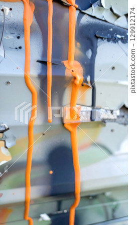 Bright Orange Paint Dripping Down a Textured Grey Wall Abstract Background Bright Orange Paint Dripping Down a Textured Grey Wall Abstract Background 129912174