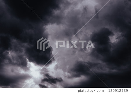 A stormy sky filled with ominous, dark heavy low clouds, creating a dramatic scene. Moody shot of a gloomy grey sky filled with swirling, storm clouds. Stormy weather. Before storm, rainstorm. A stormy sky filled with ominous, dark heavy low clouds, creating a dramatic scene. Moody shot of a gloomy grey sky filled with swirling, storm clouds. Stormy weather. Before storm, rainstorm. 129912389