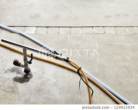 A metal pipe connected to a hose and a spigot, used for injecting termiticides into the ground. A metal pipe connected to a hose and a spigot, used for injecting termiticides into the ground. 129912834
