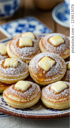 Plate of traditional dutch poffertjes with powdered sugar and butter for breakfast 129913076