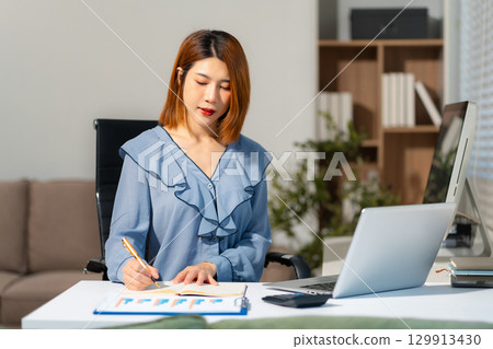 Businesswomen working with smart phone and laptop and digital tablet computer in office. 129913430