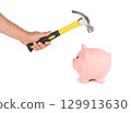 Man holding a hammer and breaking a piggy bank 129913630
