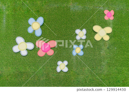 eight colorful paper flowers scattered on green grass. Brightly colored blooms in blue, pink, yellow, and white contrast with the natural background eight colorful paper flowers scattered on green grass. Brightly colored blooms in blue, pink, yellow, and white contrast with the natural background 129914430