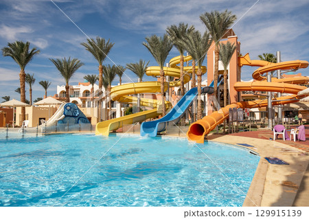 Exciting water slides and tropical scenery at an Egyptian resort in bright sunny weather Exciting water slides and tropical scenery at an Egyptian resort in bright sunny weather 129915139