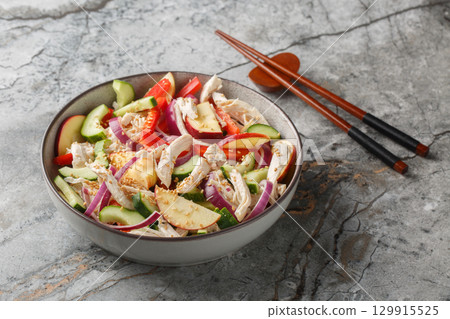 Korean Cold Salad salad with chicken, cucumber, pepper and apple tossed with tangy sesame mustard dressing closeup on the plate. Horizontal 129915525