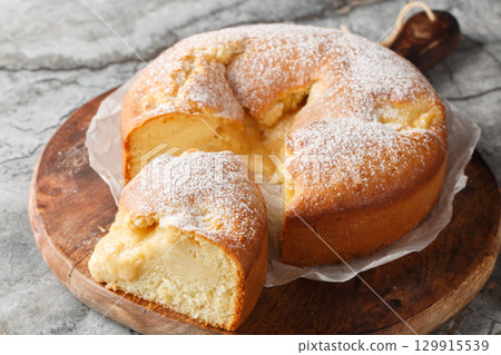 Italian Custard Cake or Torta Nua is a soft Italian cake baked with dollops of Italian pastry cream closeup on the wooden board. Horizontal Italian Custard Cake or Torta Nua is a soft Italian cake baked with dollops of Italian pastry cream closeup on the wooden board. Horizontal 129915539