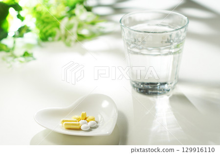 藥片和膠囊以及一杯礦泉水 129916110