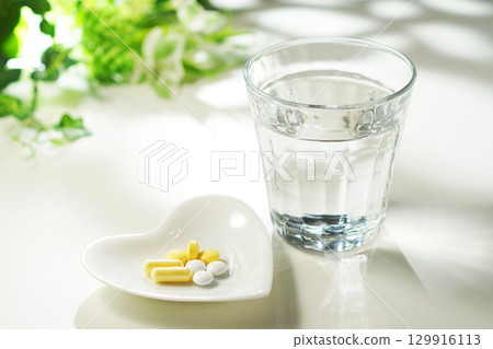 藥片和膠囊以及一杯礦泉水 129916113