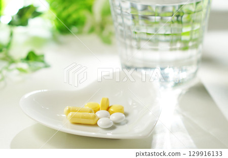 藥片和膠囊以及一杯礦泉水 129916133