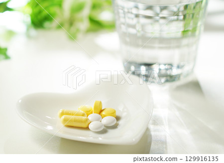 藥片和膠囊以及一杯礦泉水 藥片和膠囊以及一杯礦泉水 129916135