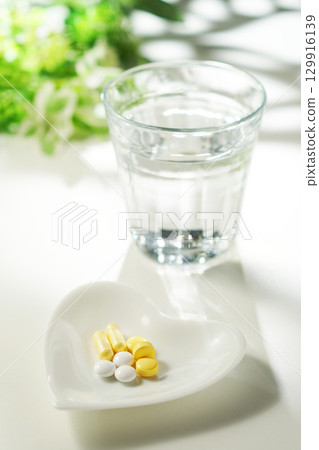 藥片和膠囊以及一杯礦泉水 129916139