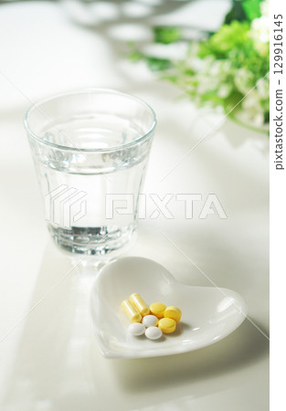 藥片和膠囊以及一杯礦泉水 129916145