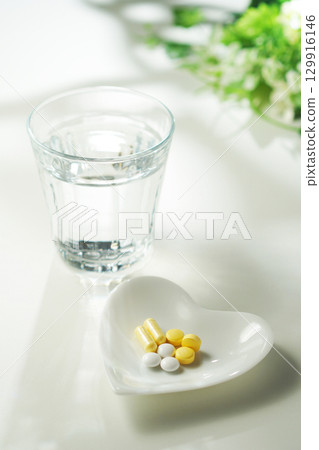 藥片和膠囊以及一杯礦泉水 129916146