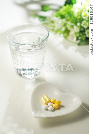 藥片和膠囊以及一杯礦泉水 129916147