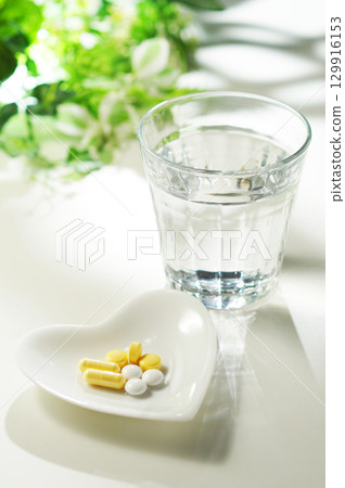 藥片和膠囊以及一杯礦泉水 藥片和膠囊以及一杯礦泉水 129916153