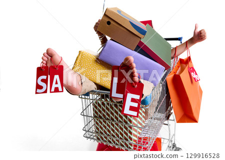 Feet holding red sale tags in shopping cart full of gift boxes 129916528