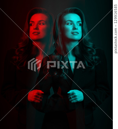 Beautiful woman with dark suit and wavy hair studio portrait in RGB color channel split effect style 129916585