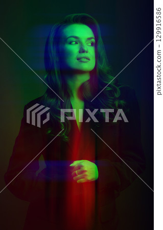 Beautiful woman with dark suit and wavy hair studio portrait in RGB color channel split effect style 129916586