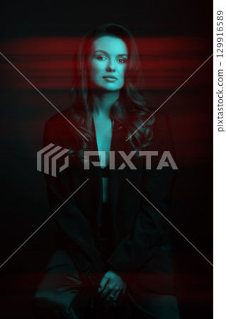 Beautiful woman with dark suit and wavy hair studio portrait in RGB color split effect style 129916589