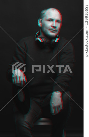 Man with sweatshirt headphones and LP vinyl studio portrait in glitch and RGB color split effect style Man with sweatshirt headphones and LP vinyl studio portrait in glitch and RGB color split effect style 129916655