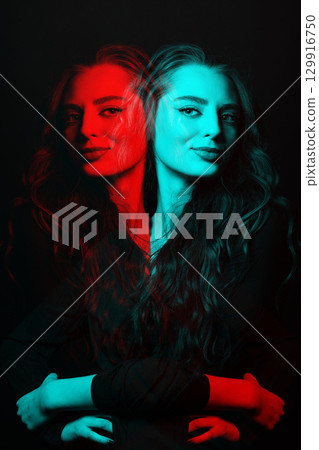 Woman with long wavy hair sensual studio portrait in RGB color split effect style 129916750