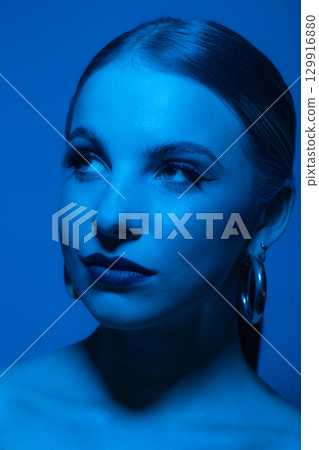 Abstract beautiful woman studio portrait with classic hairstyle and round golden earrings Abstract beautiful woman studio portrait with classic hairstyle and round golden earrings 129916880