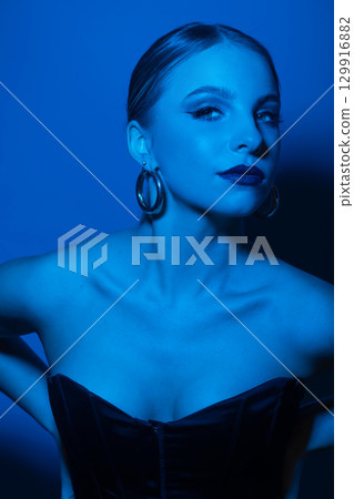 Abstract beautiful woman studio portrait with classic hairstyle, corset and round golden earrings Abstract beautiful woman studio portrait with classic hairstyle, corset and round golden earrings 129916882