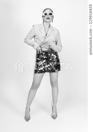 Woman black and white studio portrait with jacket and mini skirt Woman black and white studio portrait with jacket and mini skirt 129916928