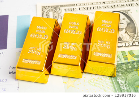 Gold bars on US dollar banknote money, finance trading investment business currency. Gold bars on US dollar banknote money, finance trading investment business currency. 129917016