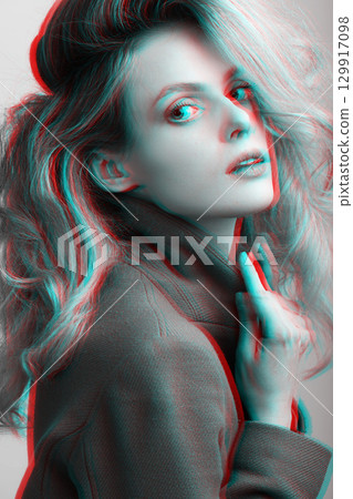 Beautiful woman with big wavy hair and garment coat studio portrait in RGB color split effect style 129917098