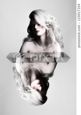 Beautiful woman with big wavy hair studio portrait with reflection effect 129917104