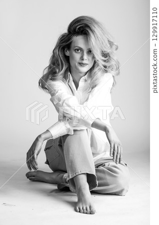 Beautiful woman with big wavy hair black and white studio portrait Beautiful woman with big wavy hair black and white studio portrait 129917110