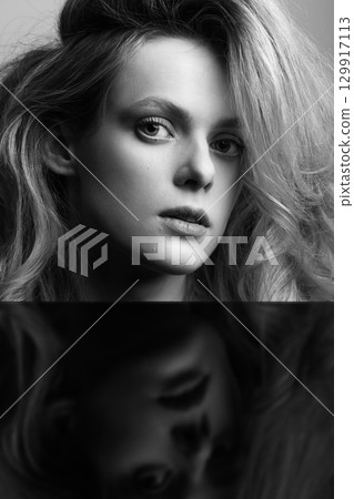 Beautiful woman with big wavy hair and black mirror reflection black and white studio portrait Beautiful woman with big wavy hair and black mirror reflection black and white studio portrait 129917113