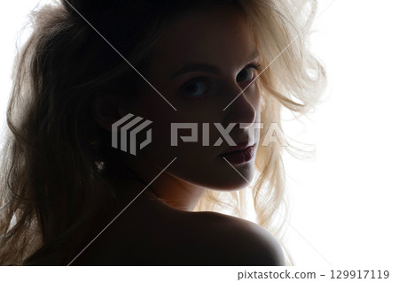 Beautiful woman with big wavy hair studio portrait in bright background 129917119