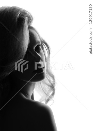 Beautiful woman with big wavy hair black and white studio portrait in bright background Beautiful woman with big wavy hair black and white studio portrait in bright background 129917120
