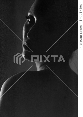 Beautiful woman dark silhouette studio portrait on gray background in grunge effect style Beautiful woman dark silhouette studio portrait on gray background in grunge effect style 129917160