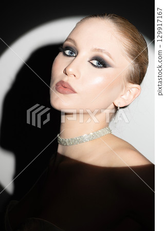 Beautiful woman portrait illuminated with bright round studio light 129917167