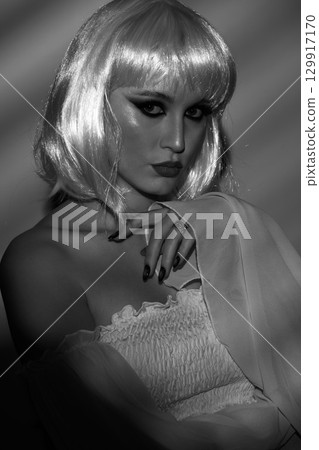 Beautiful woman with white wig illuminated by bright light through blinds Beautiful woman with white wig illuminated by bright light through blinds 129917170