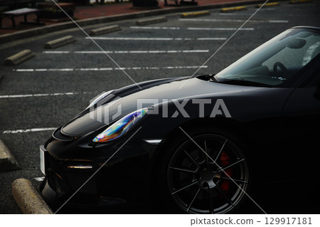 A black convertible car standing in a parking lot A black convertible car standing in a parking lot 129917181