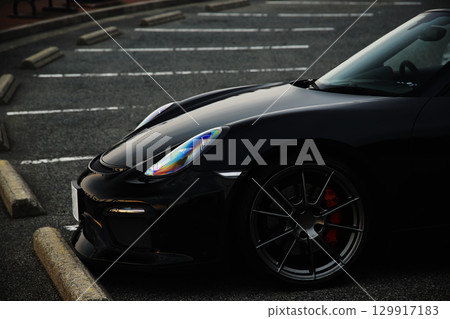 A black convertible car standing in a parking lot 129917183