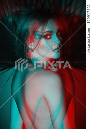Beautiful woman with naked back and palm leaf studio portrait in RGB color split effect style Beautiful woman with naked back and palm leaf studio portrait in RGB color split effect style 129917302